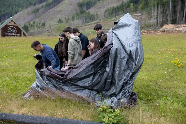 Youth working together in a mountain meadow at Youth Summer Camp 2026